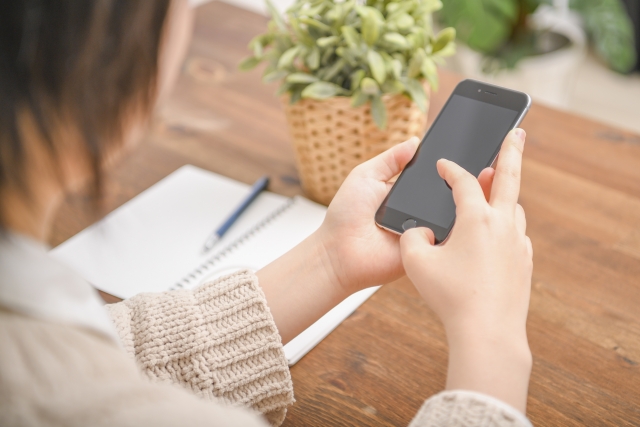 スマホを握りしめる女性