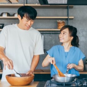 仲良くキッチンに立つカップル